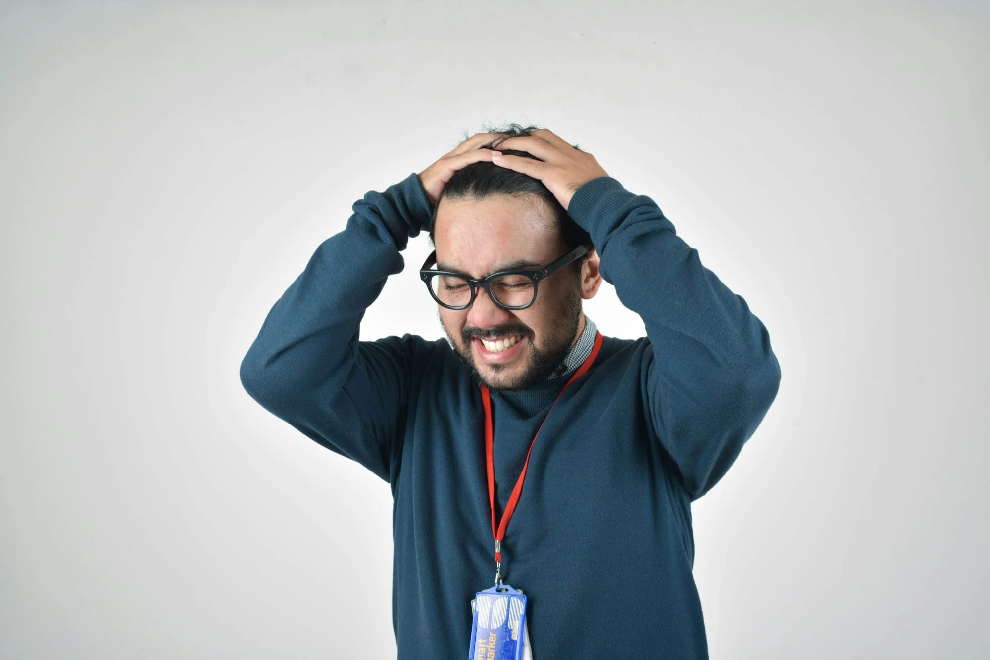 A stressed man gripping his head with both hands