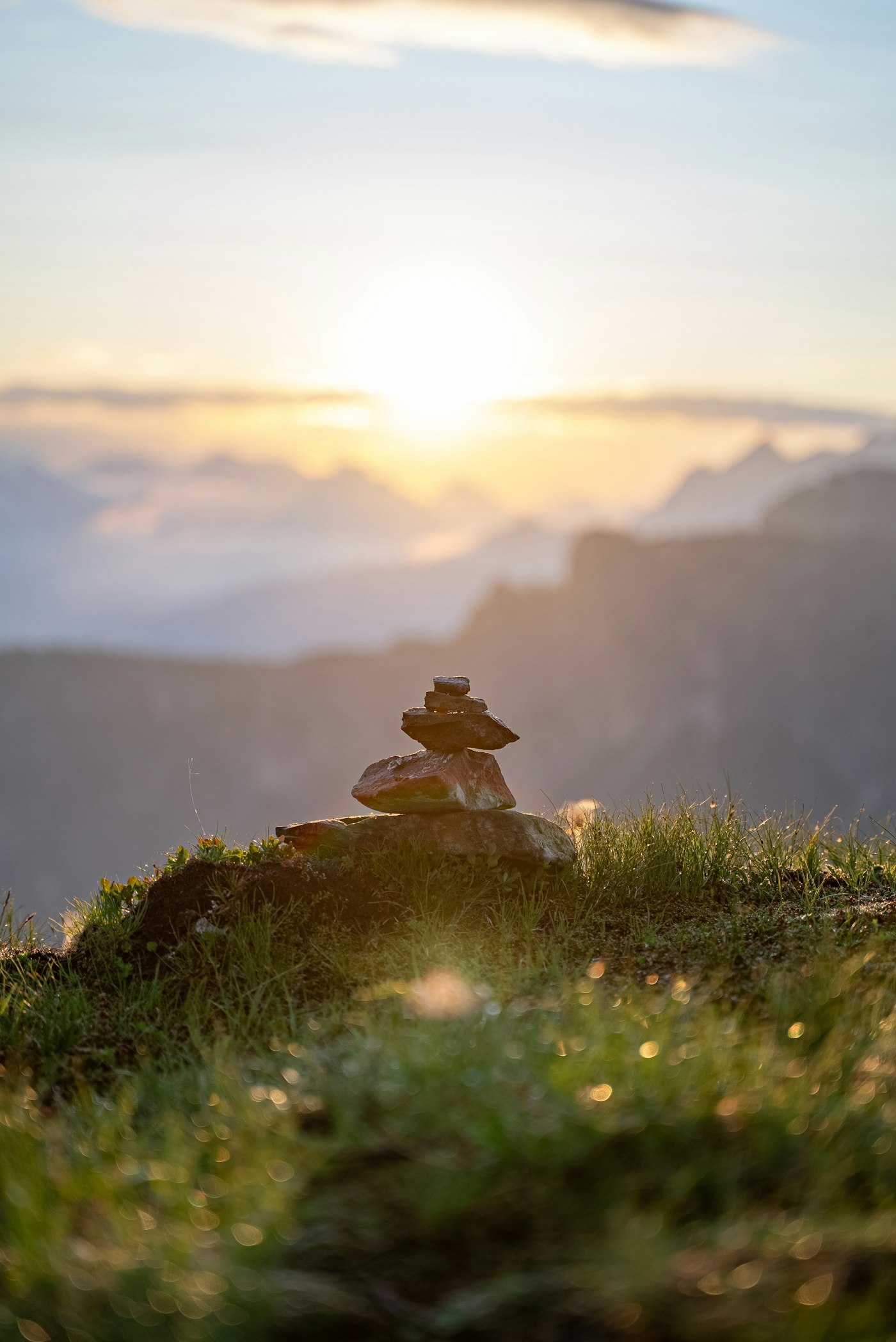 A stone cairn on a mountain ridge at sunrise